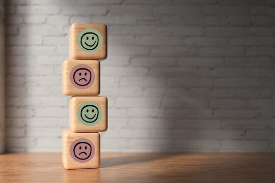stacked cubes with smiley symbols in front of a brick wall background