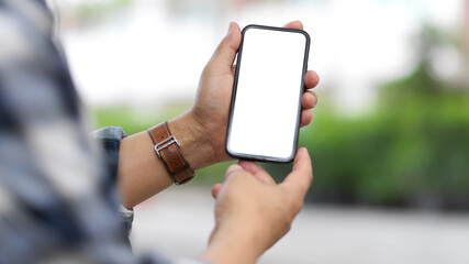 Male hands holding smartphone include clipping path screen while outdoor standing