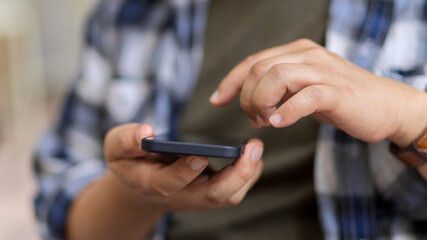 A man in Scott jacket hands using smartphone while outdoor standing
