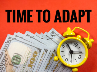 Business concept.Text TIME TO ADAPT with clock and banknoteon red background.