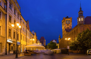 Fototapeta na wymiar Night view of lighted central Torun square with Old Town Hall and statue of Copernicus, Poland