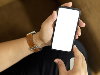 Top view of a man sitting on the couch and holding smartphone