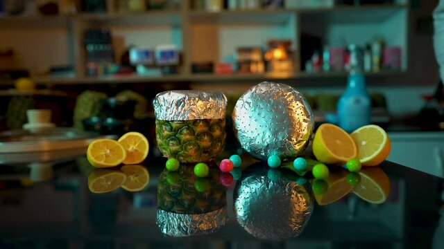 Put the pineapple hookah bowl on the table with fruit ( lemon ) and round gum in slow motion - 120 fps full shot