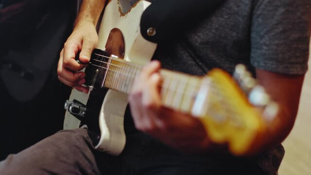 Close up of an electric telecaster guitars with a guitarists hands playing notes with a pick.Shot in 4K.
