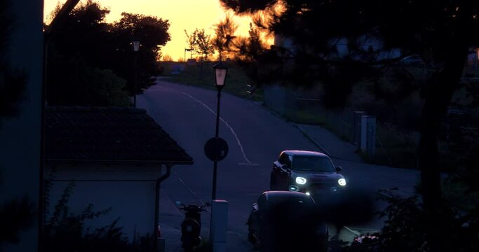 Mini Cooper Car driving down the Road 
in the early evening. the sun has just gone down