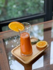 Cold pressed fruit juice with orange on wood table. Cafe concept