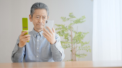 携帯電話の機種変更をするシニア男性