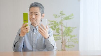携帯電話の機種変更をするシニア男性