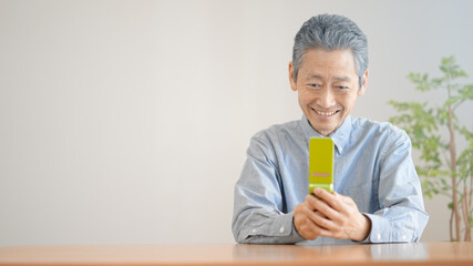 携帯電話を操作するシニア男性