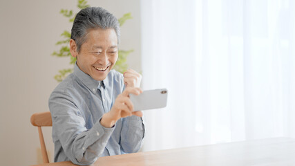 スマートフォンで動画を視聴するシニア男性