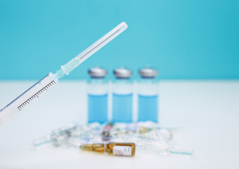 Monochromatic image of glass vials and a syringe. Plastic medical syringe and vial vaccine. A syringe is injected into a vial. Coronavirus vaccination and immunization concept. Fight pandemic.