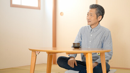和室でお茶を飲むシニア男性