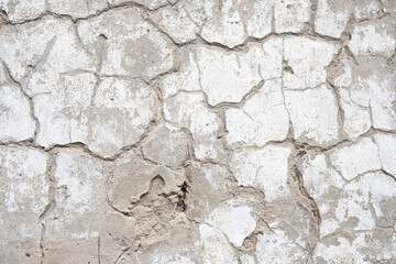 texture of an old peeling white wall, cracks, peeled off plaster