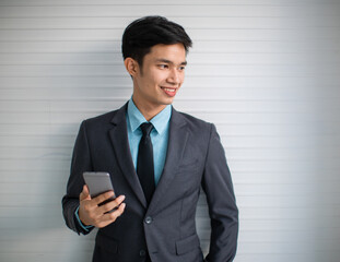 Young Asian businessman using smartphone