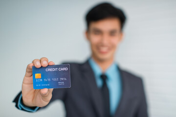 Cheerful Asian businessman advertising credit card