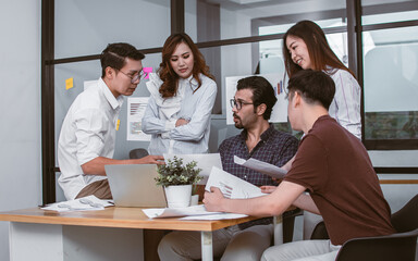 Group of mixed race working people wearing casual business shirt, meeting, presenting, discussing about jobs, project plan, analysing in laptop and paper in indoor office or workplace.