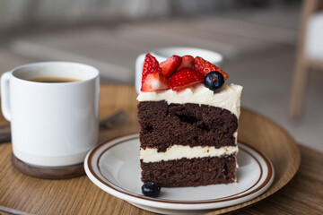 chocolate cake in white plate on wooden table background.