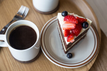chocolate cake in white plate on wooden table background.