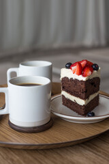 chocolate cake in white plate on wooden table background.