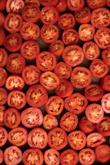 Tomato halves. Natural background with tomato slices.Top view.