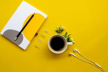 notebook planner for business work with hot coffee espresso arrangement flat lay style on background yellow