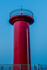 Closeup of red lighthouse with glowing red beacon light