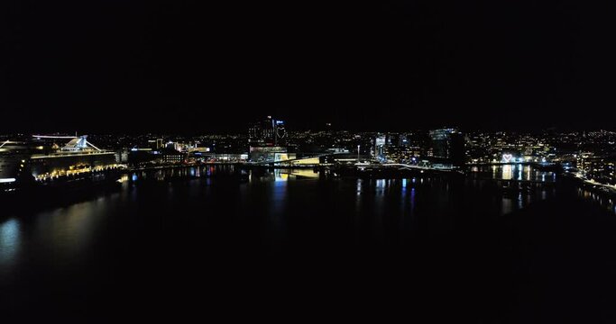Drone crane move Oslo panorama view to illuminated Opera House at night