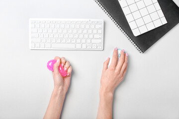 Woman squeezing stress ball while working in office
