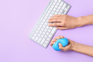 Female hands squeezing stress ball while working on color background