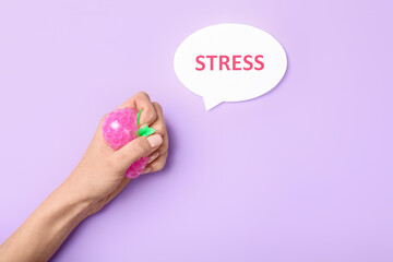 Female hand squeezing stress ball and word STRESS on color background