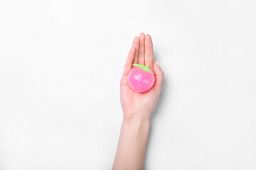 Female hand and stress ball on white background