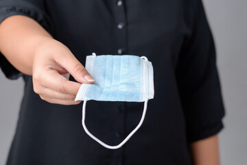 Close-up of a woman holding a  face mask covid-19.