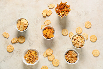 Fototapeta na wymiar Bowls with tasty different crackers on light background