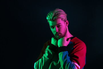 Toned portrait of handsome young man on dark background