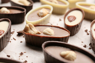 Tasty chocolate candies with nuts on table, closeup