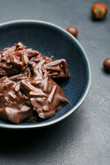 Bowl with tasty chocolate candies on dark background, closeup