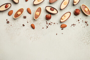 Tasty chocolate candies with nuts on light background