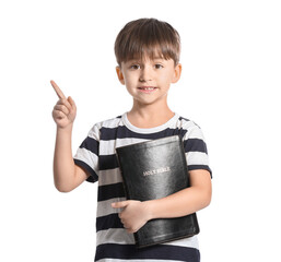 Little boy with Bible pointing at something on white background