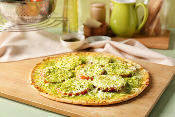 Tasty pizza with cheese and pesto sauce on table