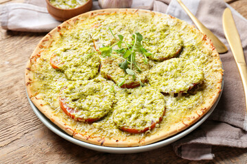 Tasty pizza with cheese and pesto sauce on wooden background