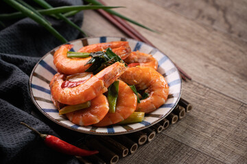 Delicious pan-fried shrimp on dark wooden table background.