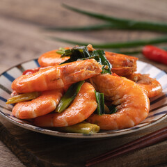 Delicious pan-fried shrimp on dark wooden table background.