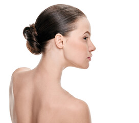Young woman with perfect healthy skin and hair in bun on white background