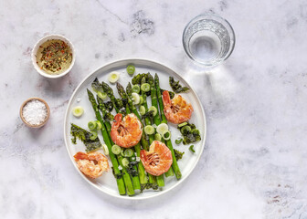 For healthy eating: Seasonal salad with grilled shrimps, green asparagus, onion, nori, and pepper oil dressing. Top view, ready to eat. 