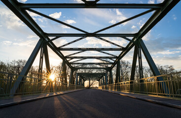 Empty bridge over a railroad during a spring sunrise.