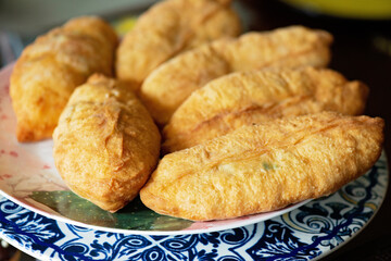 Traditional fried pies stuffed with eggs and onions, Slavic cuisine. Soft selective focus.