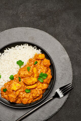 Plate of Traditional Chicken Curry and rice on stone serving board
