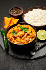 Plate of Traditional Chicken Curry, nachos and rice on stone serving board