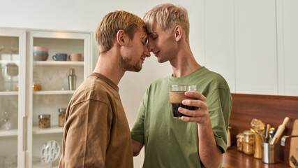 Smiling young caucasian gay pair tenderly hugging
