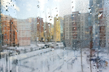 Abstract blurred background. Condensation drops on window. Winter cityscape outside window